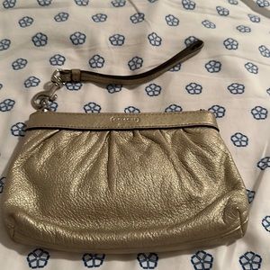 Like new, gold metallic coach wristlet.